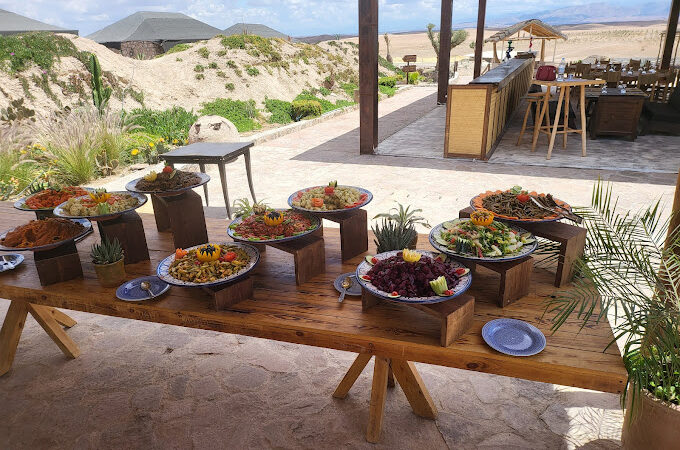 Outdoor buffet table with a variety of dishes at a camp in Agafay.